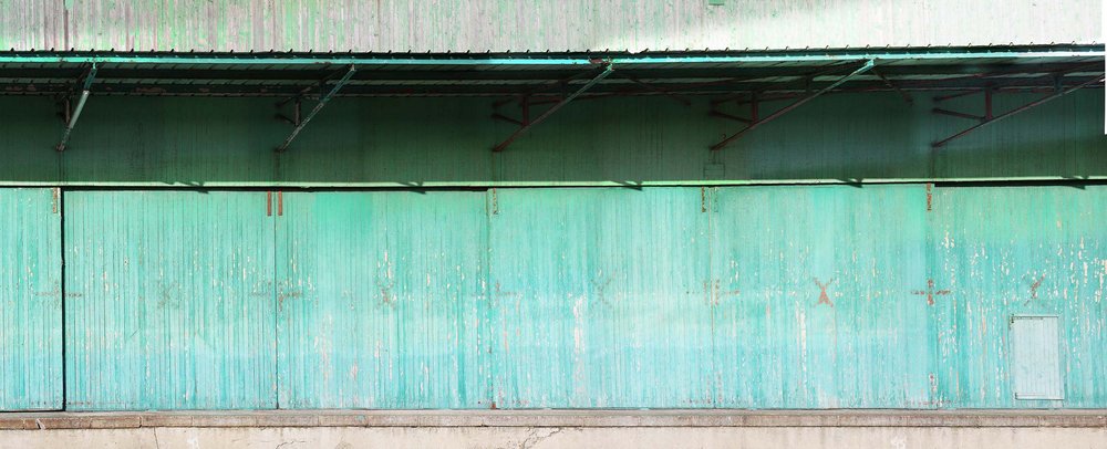 papier peint panoramique matière brute présentant une porte bleue en bois